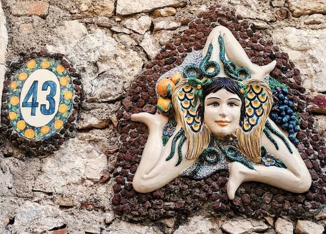 Sicilian Façade Adorned with Colorful Ceramic Religious and Folkloric Scenes and Lush Mediterranean Hanging Plants - Image 3